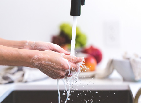 washing hands at kitchen sink