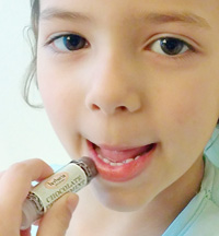 child applying lip balm